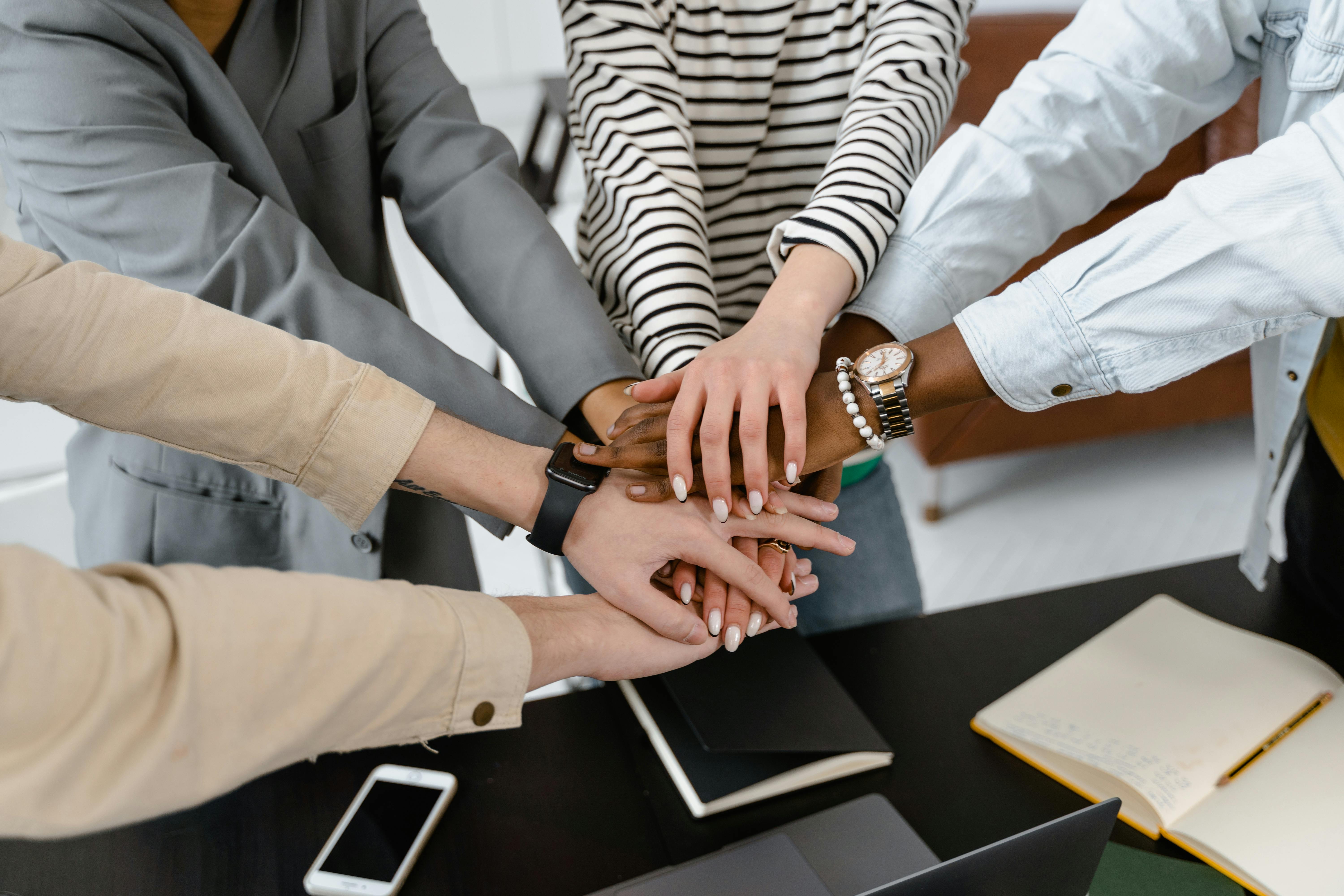 Team putting hands together in solidarity showing collaboration and unity